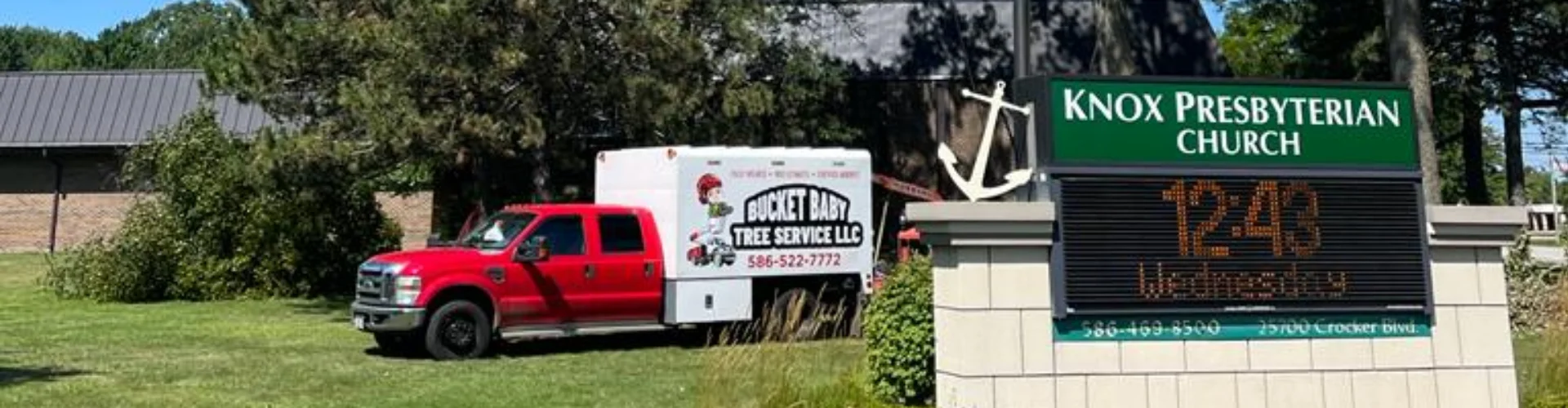 Bucket Baby Tree Service truck behind a sign